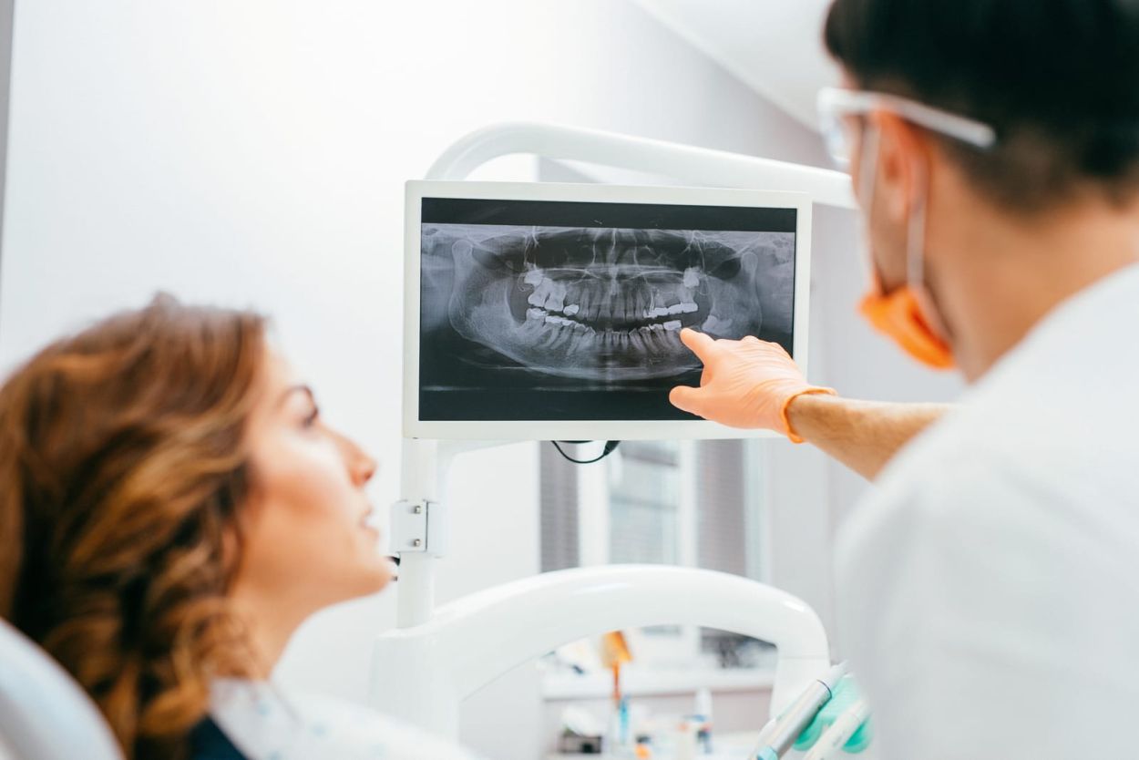 Dentist explaining an X-ray to a patient in the treatment room